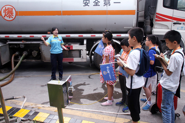 中石油吉乐加油站经理周萍正在向小记者介绍卸油过程。新华网发（喻盾 摄）.jpg