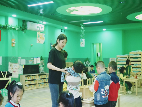 幼儿老师帮助幼儿穿衣。.jpg 幼儿老师帮助幼儿穿衣。.jpg