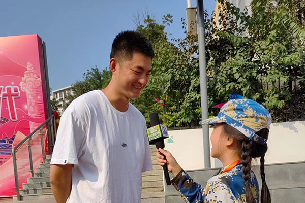 活动现场,一位老师向小记者分享他感受到的校园变化。.jpg 活动现场,一位老师向小记者分享他感受到的校园变化。.jpg